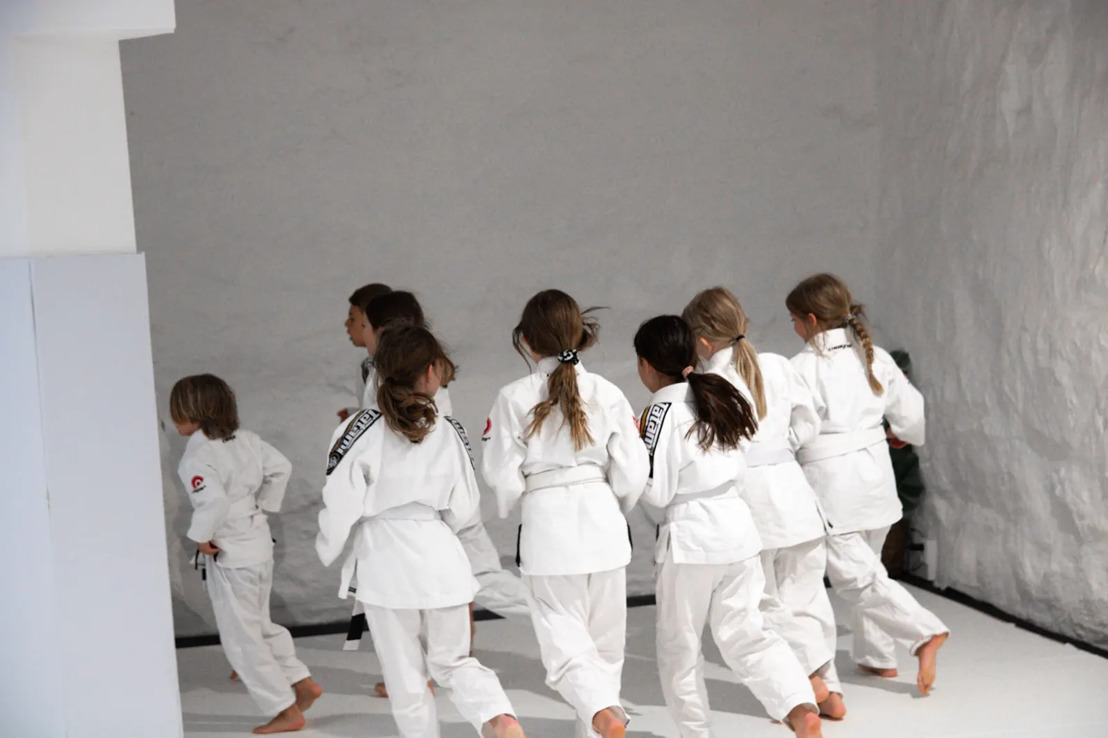 Kids running across the mat during warm-up